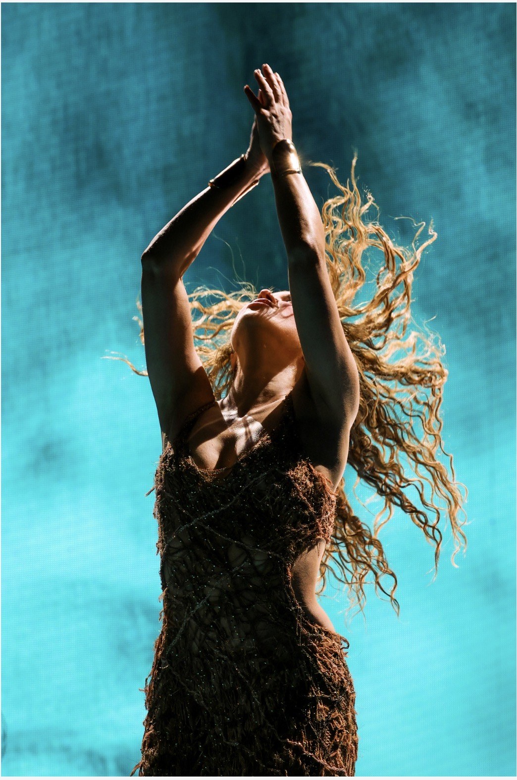Shakira de perfil sobre fondo azul en su concierto de Madrid
